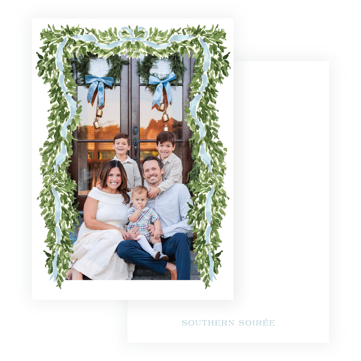 A white greeting card with a custom family photo framed by a green leafy garland and light blue ribbon border.