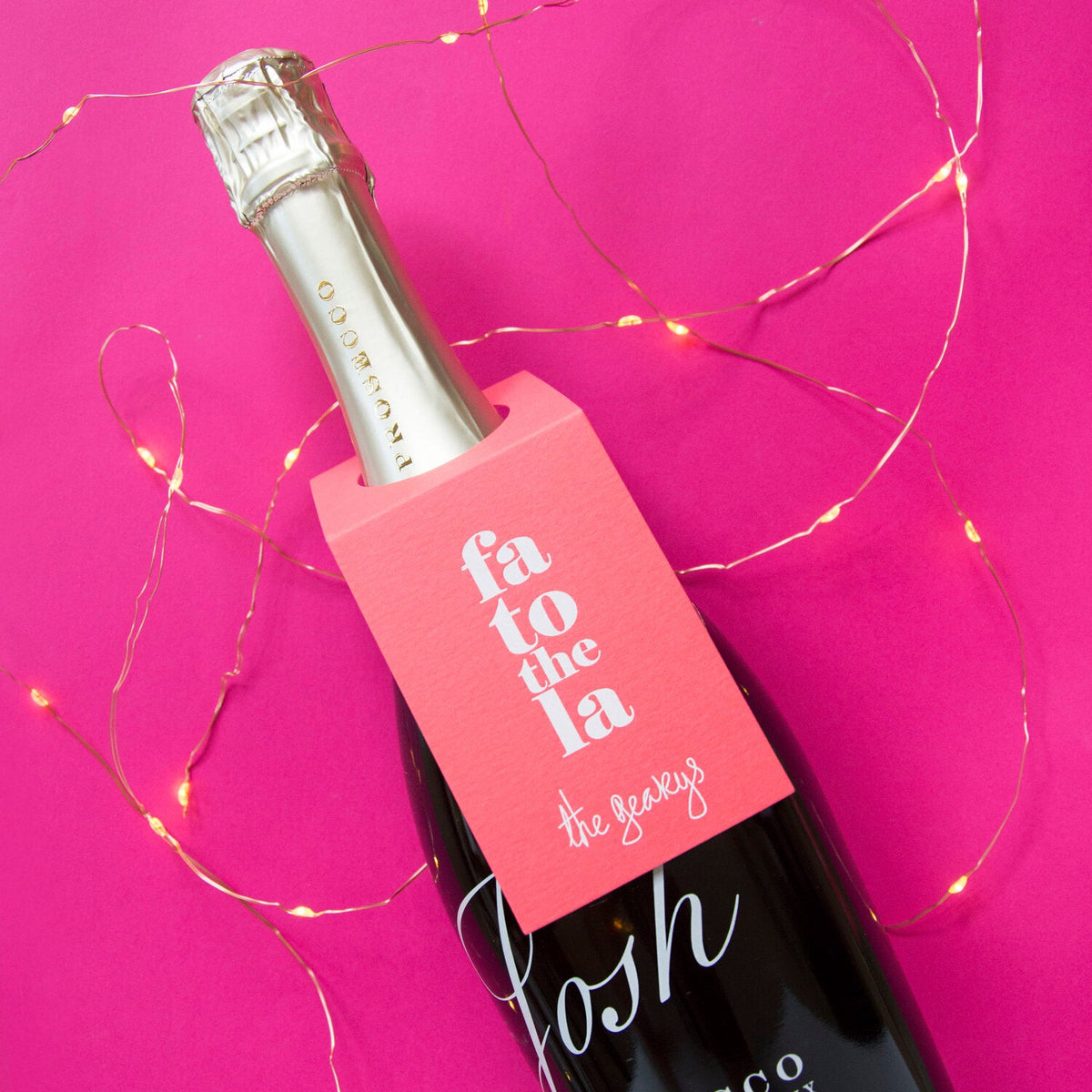 Prosecco bottle with pink label on a pink background