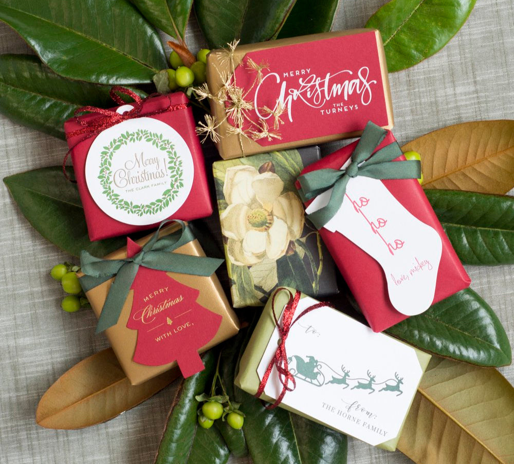 Decorative Christmas wreath with gift boxes and festive tags on a textured fabric background
