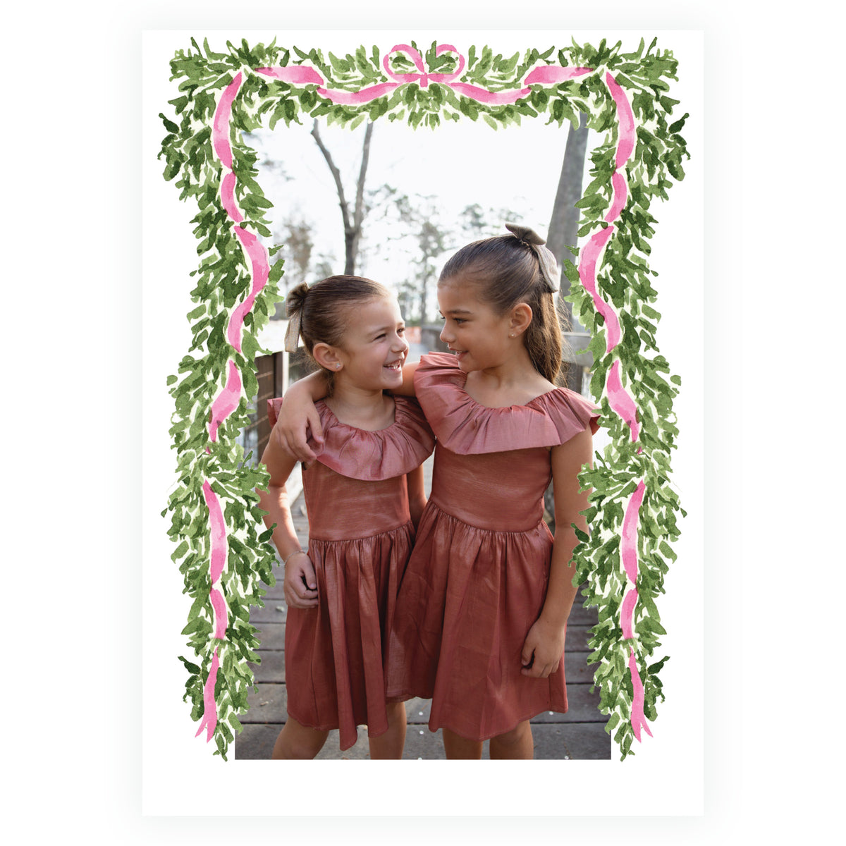 Full frame family Christmas photo card with greenery and pink ribbon